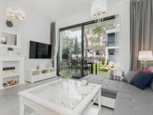 a living room with a couch and a table at Comfortable holiday home with garden, summer pool in Pobierowo