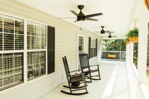 a porch with two chairs and a ceiling fan at 6 min from Downtown Dahlonega, Wine Country, Game Room in Dahlonega