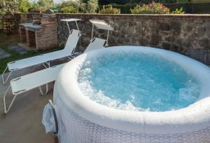 Una gran bañera de hidromasaje con sillas y una mesa. en Il Rifugio di Andrea, en Lammari