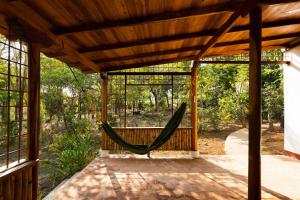 un hamac dans le porche grillagé d'une maison dans l'établissement The Boom Cottage, à Aposentillo