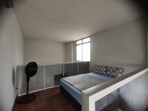 a small bedroom with a bed and a window at Apto de frente pro mar - 10 min da praia do morro - 08 in Guarapari +20 photos