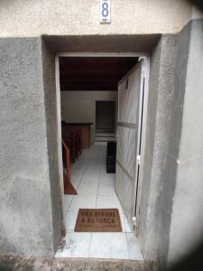 an entrance to a garage with a sign on the door at Apto de frente pro mar - 10 min da praia do morro - 08 in Guarapari