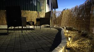 a patio with chairs and a fence with lights at Estadia dos Sonhos in Sequeiros