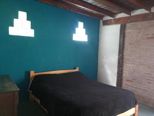 a bedroom with a bed and two lights on the wall at Lo de Charo in Miramar