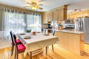 a kitchen with a table with chairs and a refrigerator at 1 Mi to Capron Park Zoo Quiet Family Getaway in Attleboro
