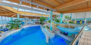 an indoor swimming pool with a water slide in a resort at Apartmán Schwaderbach in Bublava