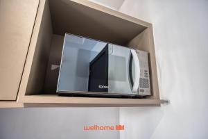 a microwave oven sitting on top of a shelf at Studio na Vila Mariana proximo a Unifesp e Estacao in Sao Paulo