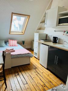 Cette petite chambre comprend un lit et une cuisine. dans l'établissement Charming Place 2 min from L'Arc de Triomphe, à Paris