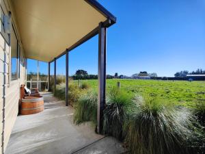 eine Veranda eines Hauses mit Rasen in der Unterkunft Glenwood Cottage in Kennington
