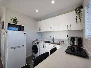 eine Küche mit einem weißen Kühlschrank und einer Waschmaschine in der Unterkunft Glenwood Cottage in Kennington + 10 Fotos