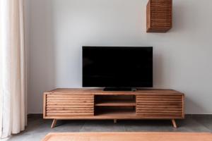 a flat screen tv sitting on top of a wooden entertainment center at Villa sunset piscina privada in Luque