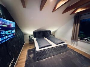 a bedroom with a bed and a flat screen tv at Alb Appartement - gemütliche Wohnung mit Balkon in Balingen