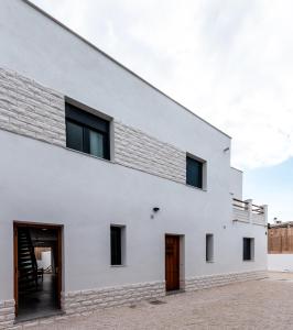 a white house with black windows and a door at Villa sunset piscina privada in Luque