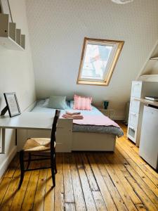 une chambre avec un lit et un bureau avec une fenêtre dans l'établissement Charming Place 2 min from L'Arc de Triomphe, à Paris