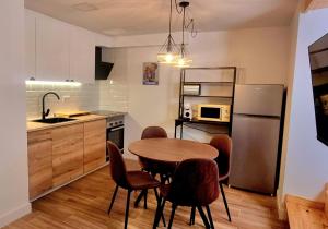a kitchen with a table and chairs and a refrigerator at Llivia 1876 in Llivia