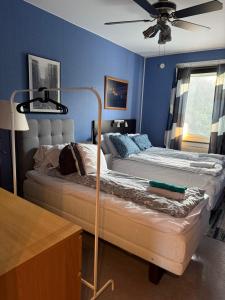 a bedroom with two beds and a ceiling fan at Apartment in South West Stockholm w Balcony near Metro, convenient to Avicii Arena, 3 Arena, Friends Arena and Royal Opera in Stockholm