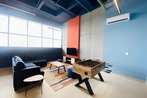 a living room with a ping pong table and a couch at Beautiful apartment, BBQ, A.C, 5 min Arena, Gym in Contla