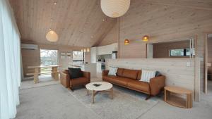 a living room with a couch and a table at Luxe on the Lake Front in Te Anau