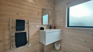 a bathroom with a white sink and a mirror at Luxe on the Lake Front in Te Anau +30 photos