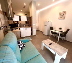 a living room with a couch and a table and a kitchen at New studio next to Ruzafa in Alcácer +6 photos