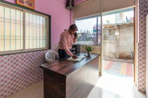 a man standing at a counter talking on a cell phone at SPOT ON Shree Gajanan in Aurangabad