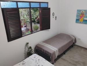 a bedroom with a bed and a window at Hospedaria Su in Parnamirim