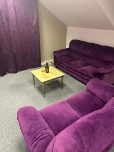 a living room with purple couches and a coffee table at B&M Studio self-check in in Vilnius