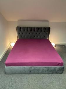 a bed with a purple blanket on top of it at B&M Studio self-check in in Vilnius +7 photos