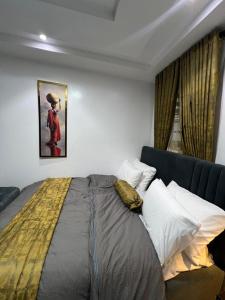 a bedroom with a bed and a painting on the wall at Ladi's place Anthony Ikeja in Lagos +24 photos