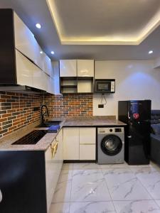 a kitchen with a washing machine and a microwave at Ladi's place Anthony Ikeja in Lagos