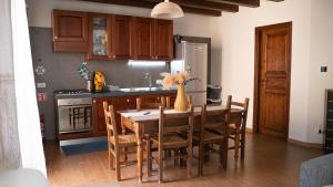 a kitchen with a wooden table and chairs and a kitchen with a refrigerator at Appartamento con Vista sul Mare a Termini Imerese - Eden Holiday Home in Termini Imerese