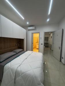 a bedroom with a large white bed and a kitchen at Roxy's Home In Rome in Rome