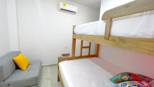 a small room with two bunk beds and a couch at Habitación Manglares 102 in Coveñas +14 photos