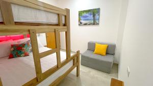 a bedroom with a bunk bed and a couch at Habitación Manglares 102 in Coveñas