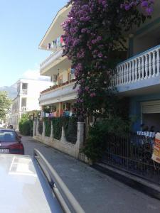a building with purple flowers on the side of it at Apartmani Lalo Jankovic in Sutomore