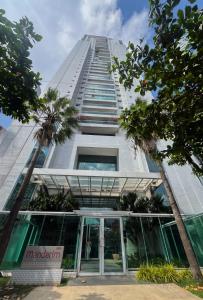a tall building with glass doors and palm trees at COP30 - Apê Amazônia Living - Sem reserva mínima - 4 Camas - Umarizal - Belém in Belém +39 photos