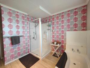 a bathroom with a shower and a bath tub at Korimako Sea View Sanctuary in Riverton +31 photos