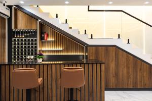 un bar avec deux chaises et un escalier dans l'établissement Throne, à Santeo