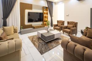 un salon avec une télévision, des canapés et une table dans l'établissement Throne, à Santeo