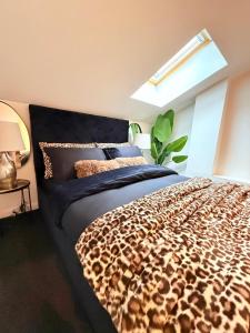 a bedroom with a leopard print bed with a window at Designer 2-Bed Flat by Tower Bridge in London