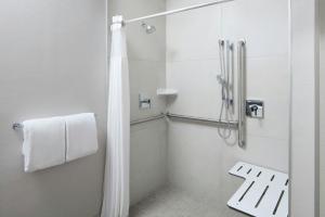 a bathroom with a shower with a shower curtain at Courtyard by Marriott Waldorf in Waldorf +9 photos