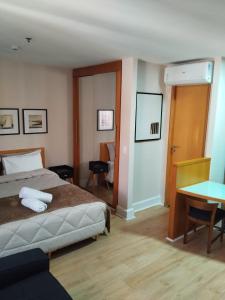 a bedroom with a bed and a desk and a table at CONFORT iNN EXECUTIVE FARIA LIMA in Sao Paulo