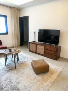a living room with a large television and a table at Studio meublé premium in Dakar