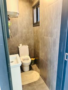 a small bathroom with a toilet and a sink at Studio meublé premium in Dakar