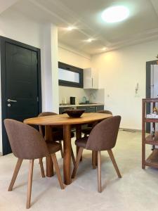 a wooden table and chairs in a living room at Studio meublé premium in Dakar +6 photos