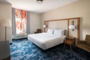 a hotel room with a large bed and a chair at Fairfield Inn & Suites by Marriott Somerset in Somerset