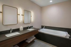 a bathroom with two sinks and a tub with two mirrors at Fairfield Inn & Suites by Marriott Somerset in Somerset