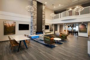 a lobby with tables and chairs and a fireplace at Fairfield Inn & Suites by Marriott Somerset in Somerset