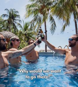 un groupe d'hommes dans une piscine tenant une bouteille de bière dans l'établissement The Boom Cottage, à Aposentillo