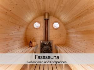 a wooden cabin with a stove in the middle at TinyHousebeiDresden spektakuläres winziges Häuschen auf Stelzen im Pferdeteich, Kaminofen, umlaufende Terrasse - Nähe Sächsische Schweiz - Von Juni - September Mindestmietzeit 1 Woche Sa-Sa in Großharthau